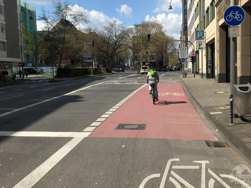 Auf einer breiten Straße in Köln ist die rechte Spur Radfahrenden vorbehalten.