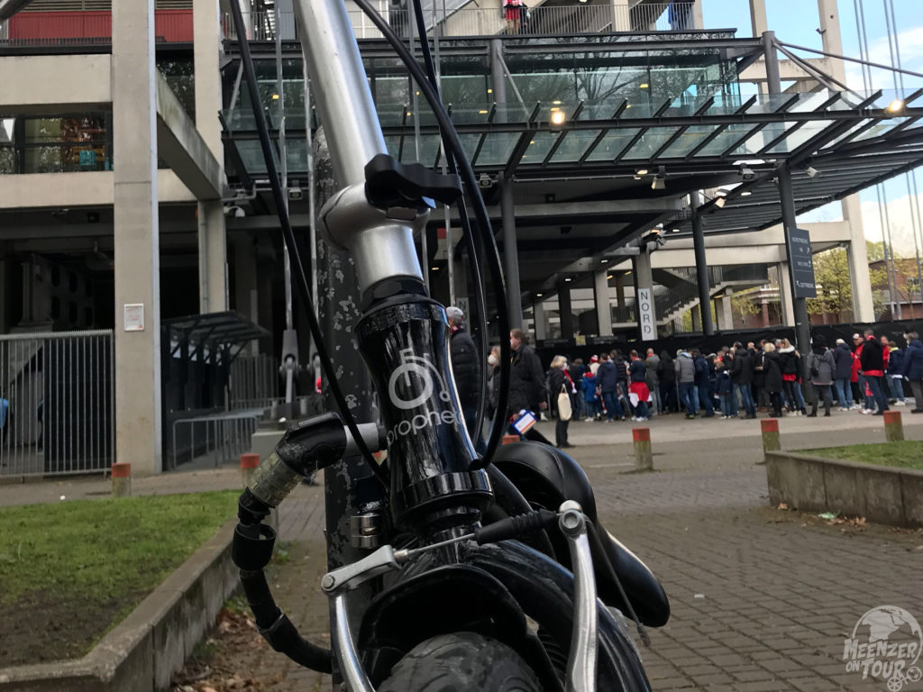 Ein Klapprad parkt direkt vor dem Stadioneingang in Köln-Müngersdorf.