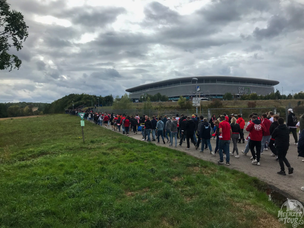 Menschen laufen auf einem Weg zum Stadion